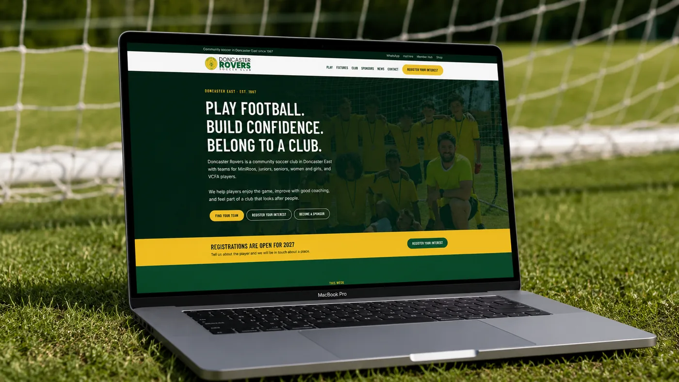 The Doncaster Rovers Soccer Club home page open on a laptop, standing on grass in front of a goal net.